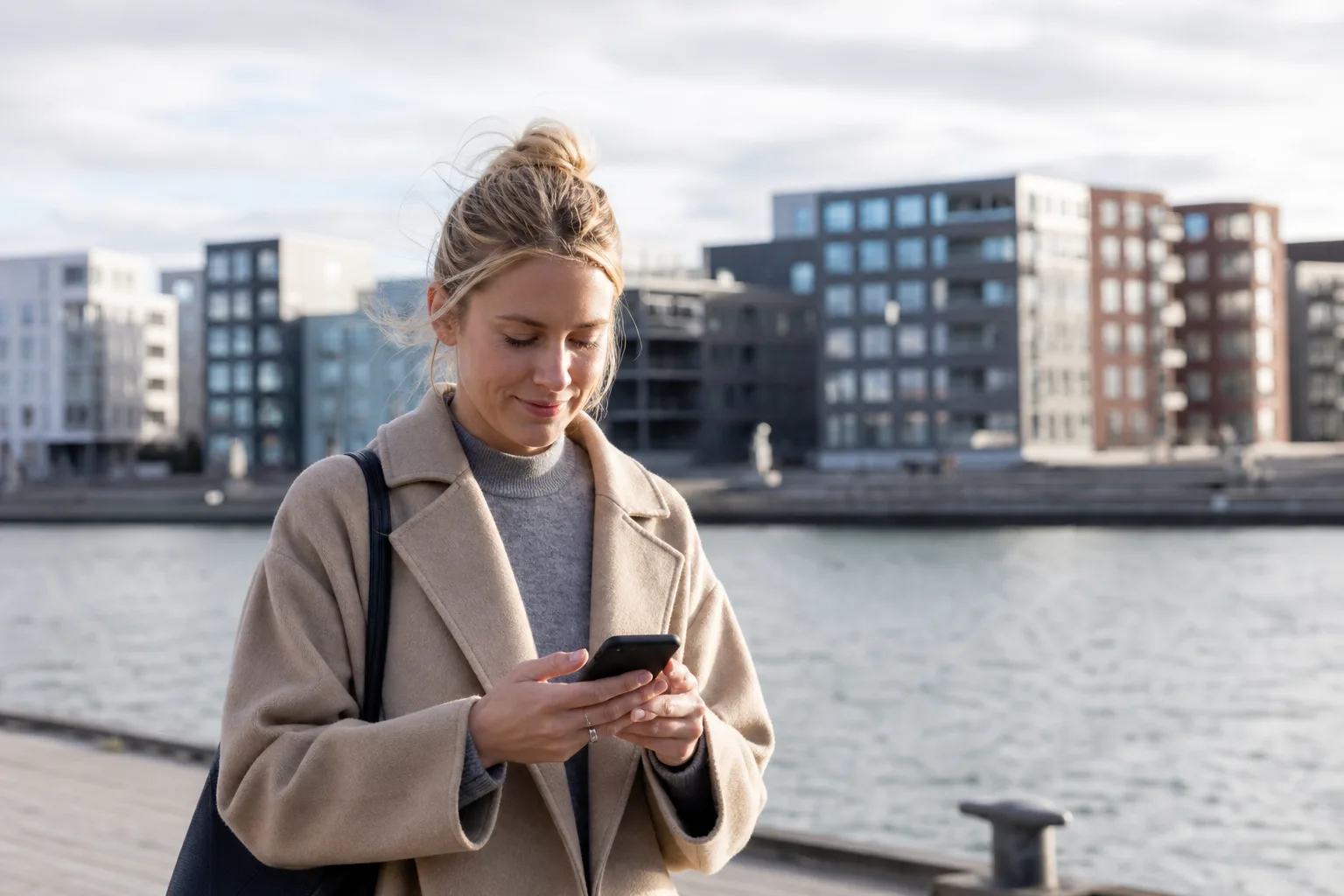 Person använder snabb 5G-surf i mobilen utomhus i en nordisk stadsmiljö